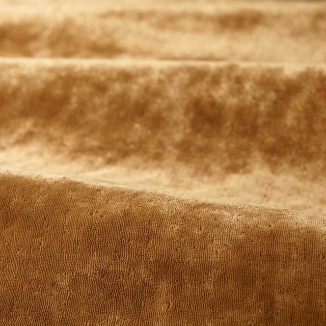 Close-up of warm amber-brown plain pile with fine vertical ribbing and soft sheen