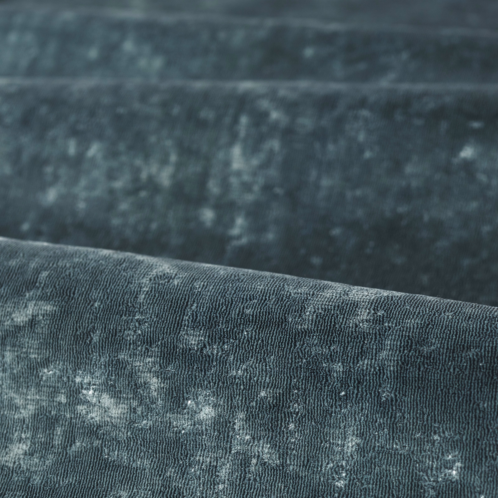 Deep smoky azure blue fabric with fine vertical ribs and mottled pale-blue highlights