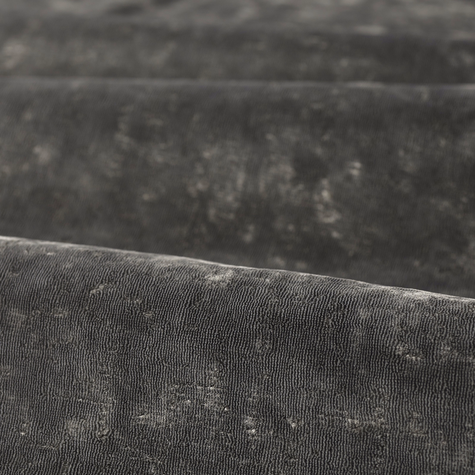 Close-up of charcoal ribbed fabric with pale grey mottled flecks