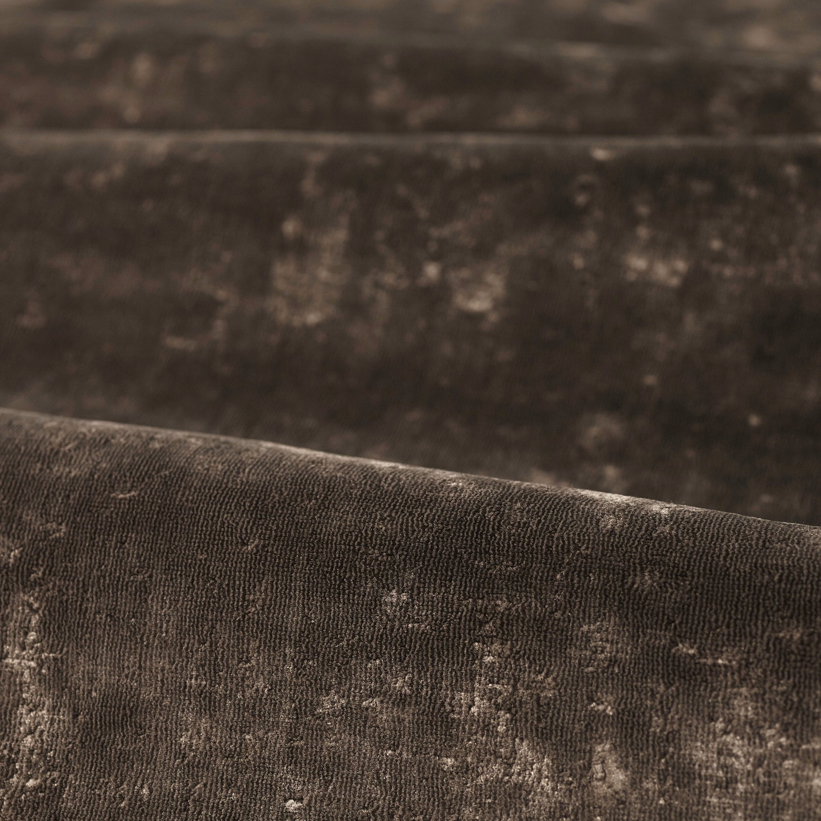 Close-up of deep chocolate brown fabric with ribbed pile and softly mottled highlights