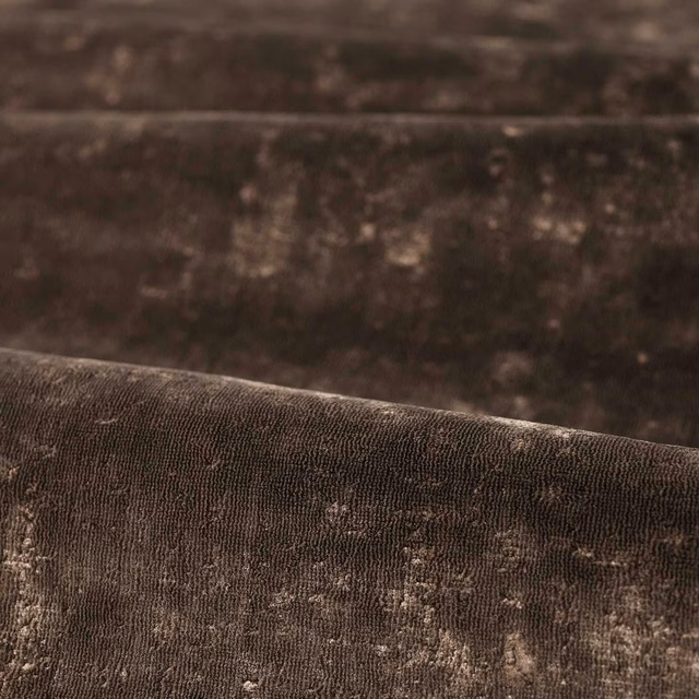 Close-up of deep chocolate brown fabric with ribbed pile and softly mottled highlights
