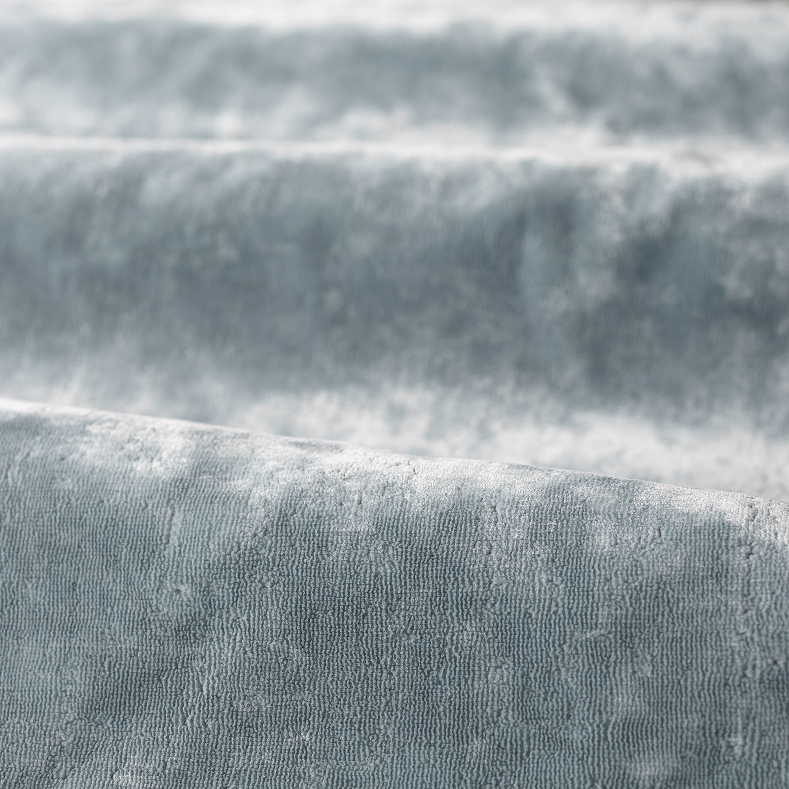 Misty blue-grey plain fabric with plush rippled vertical texture catching soft light