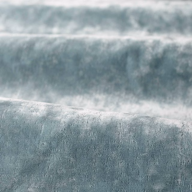 Misty blue-grey plain fabric with plush rippled vertical texture catching soft light