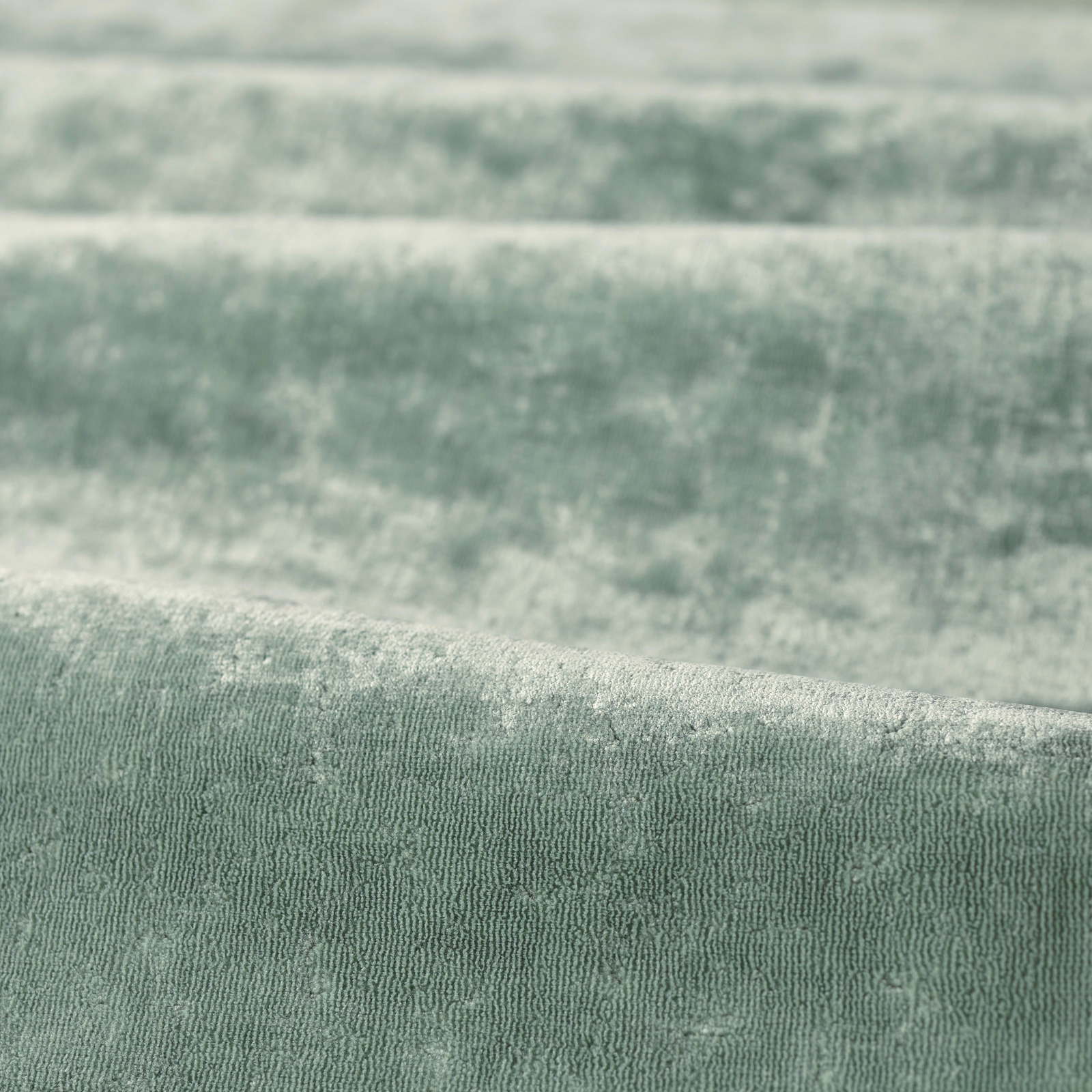 Soft eau de nil green fabric with fine irregular woven ridges and tonal shading