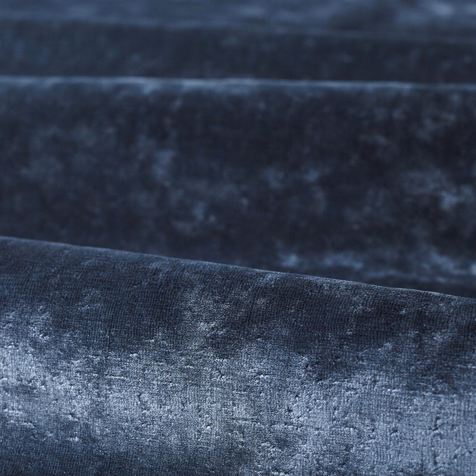 Deep indigo plain textile with smoky blue mottling and a soft lustrous texture