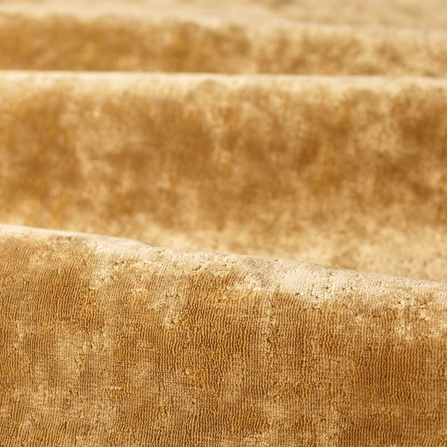 Plush old-gold fabric with mottled velvet pile and fine vertical rib texture
