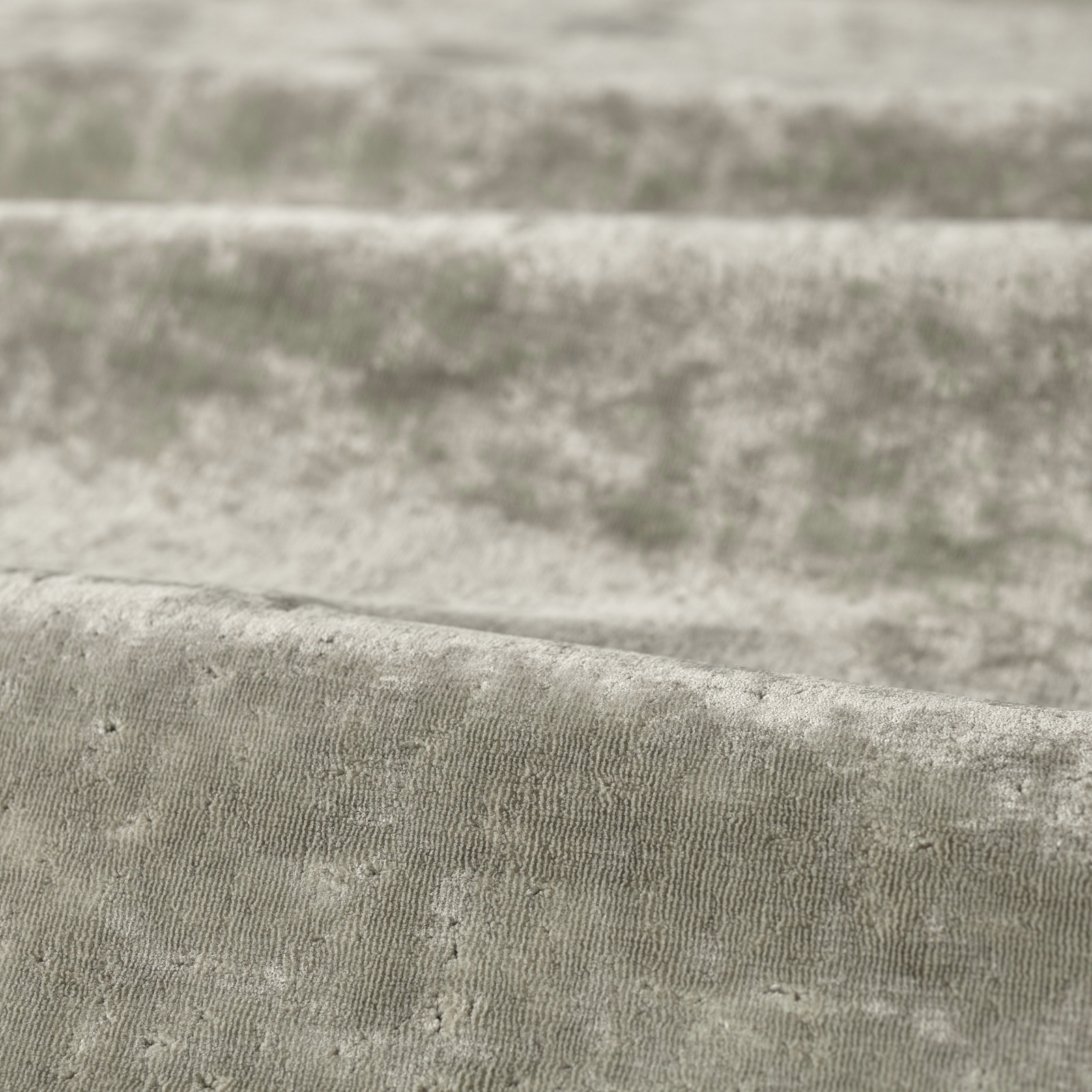 Close-up of cool platinum grey ribbed fabric with softly mottled, cloudy texture