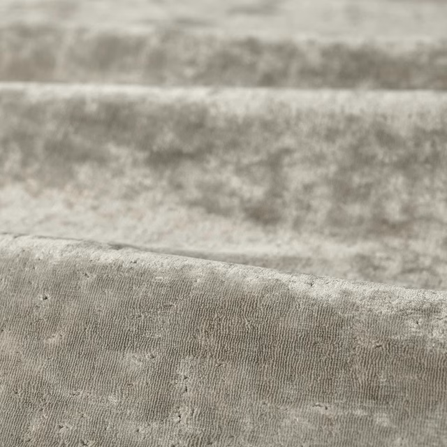 Close-up of cool platinum grey ribbed fabric with softly mottled, cloudy texture