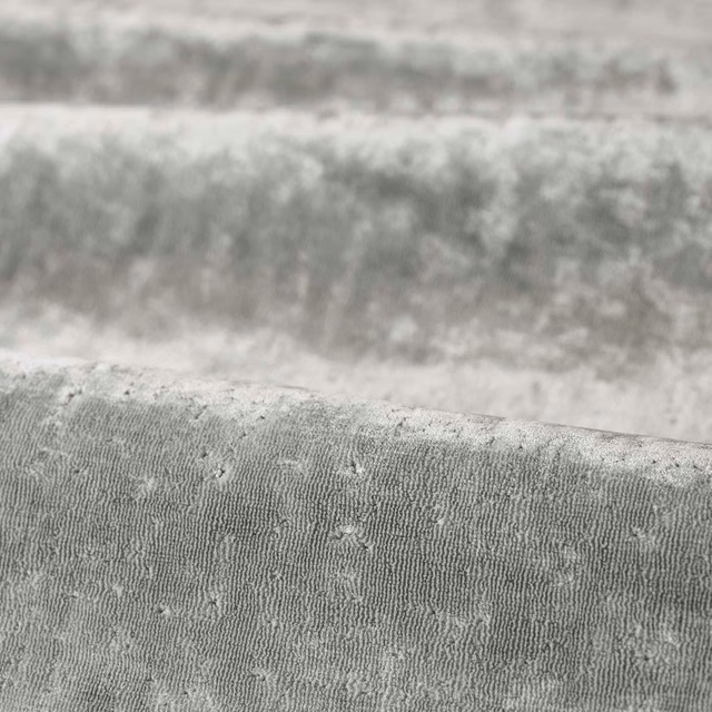 Cool silver-grey woven cloth with fine vertical ridging and softly raised flecks