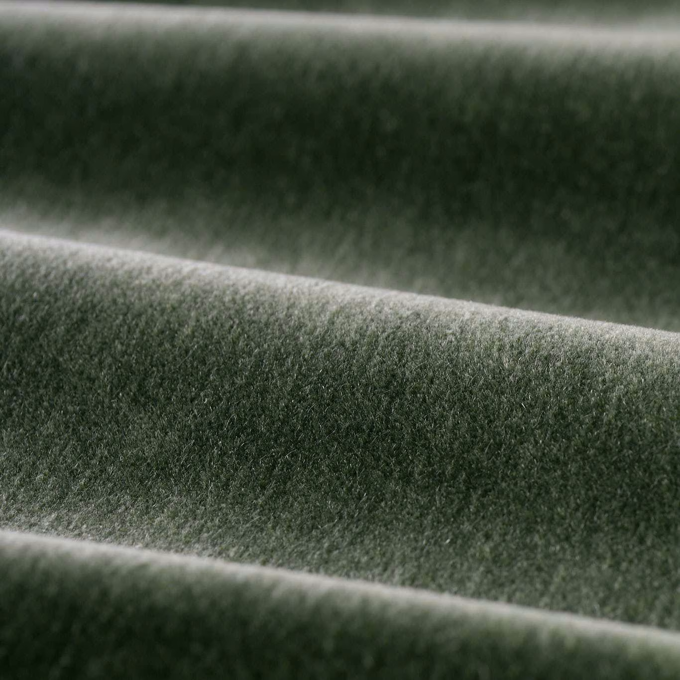 Deep moss-green velvet folds showing a dense plush pile and silvery highlights