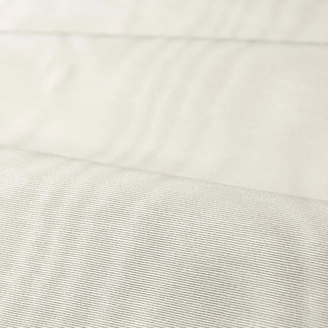 Close-up of pale silver-grey fabric with fine horizontal ribbing and soft sheen