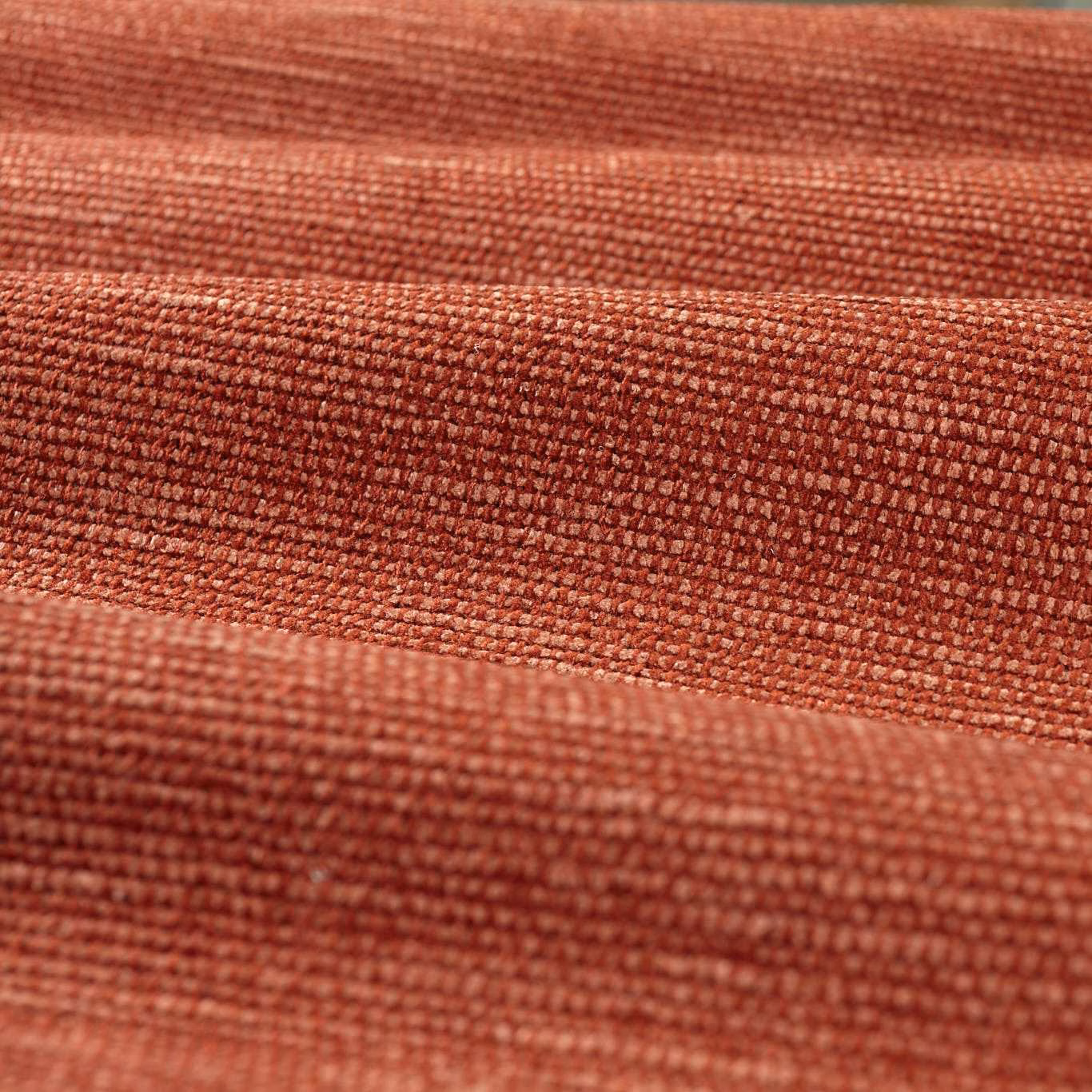 Close-up of warm Venetian red chenille with a dense, softly ridged weave