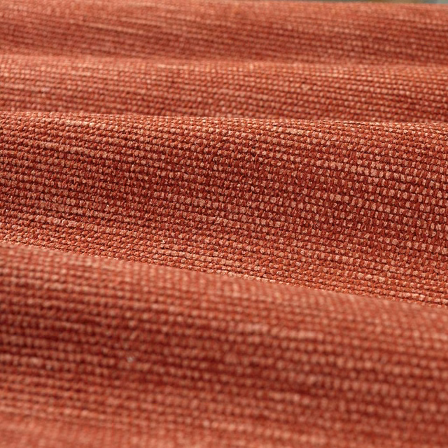 Close-up of warm Venetian red chenille with a dense, softly ridged weave