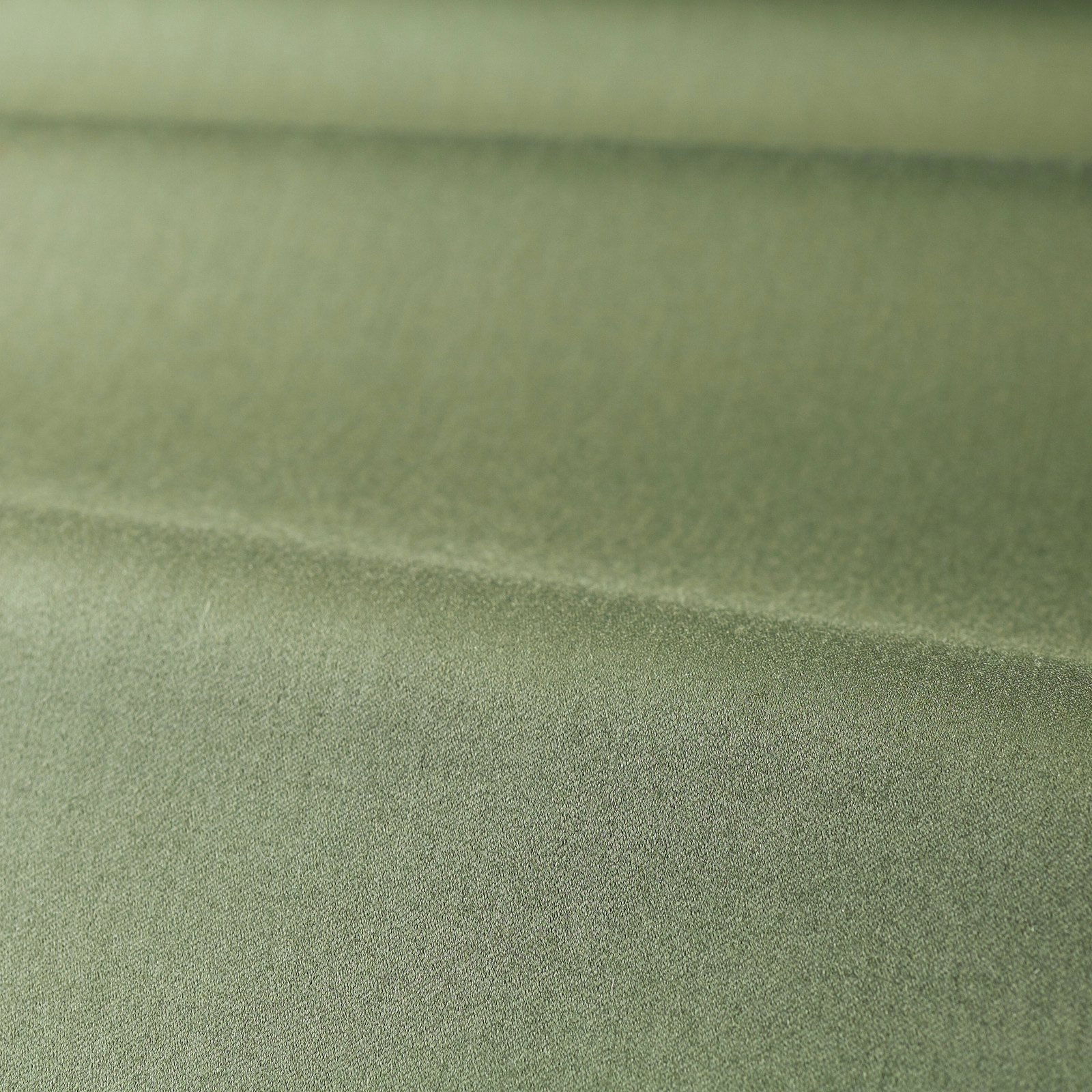 Close-up of muted sage green plain fabric with a soft satin sheen and fine texture