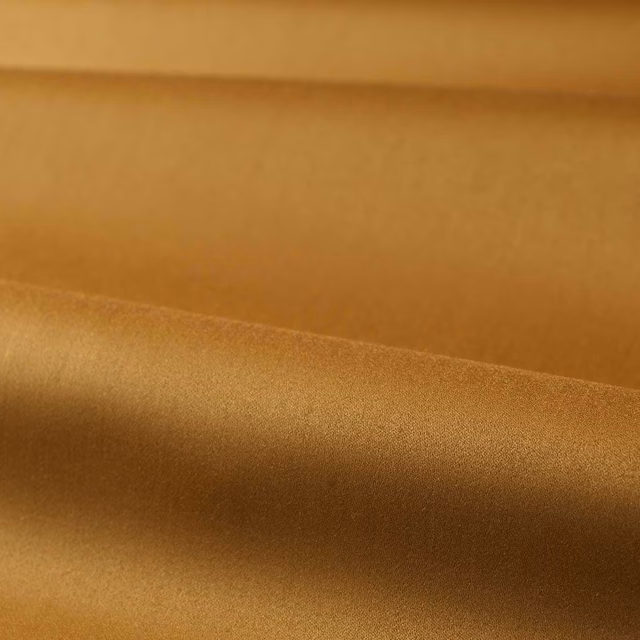 Warm muddy amber satin surface with bronze highlights and smooth directional sheen