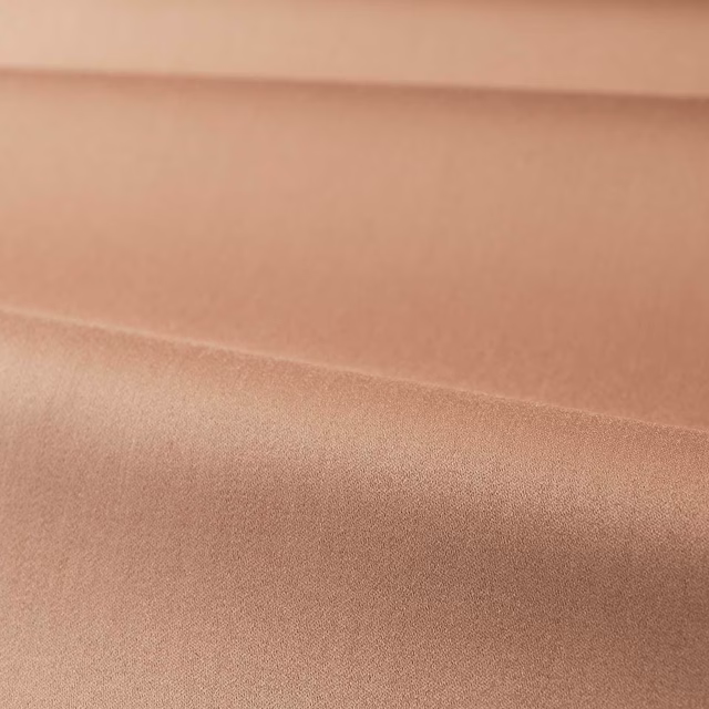 Close-up of smooth Tuscan pink satin with a soft horizontal fold and muted sheen