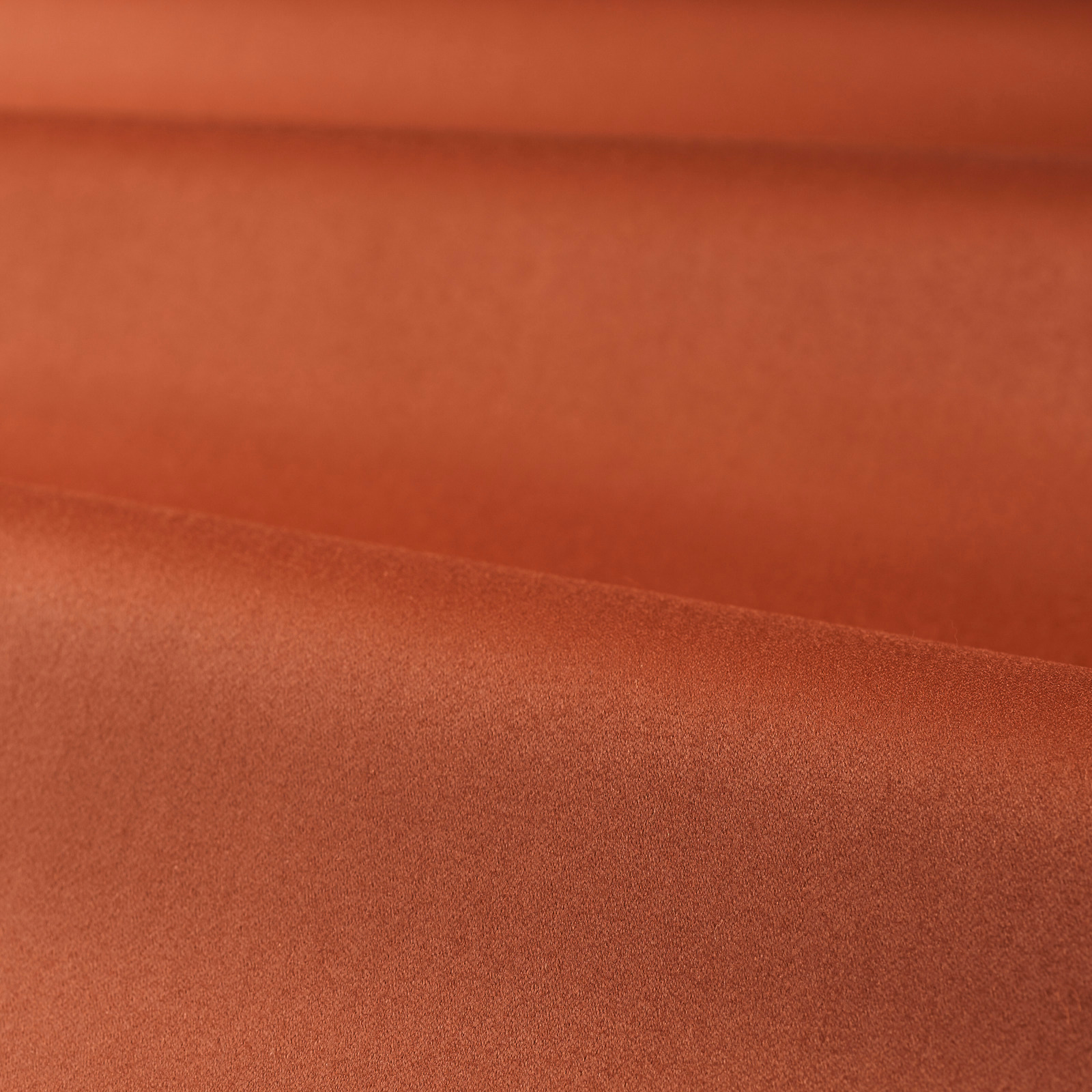 Burnt terracotta red satin with a smooth, softly luminous folded surface