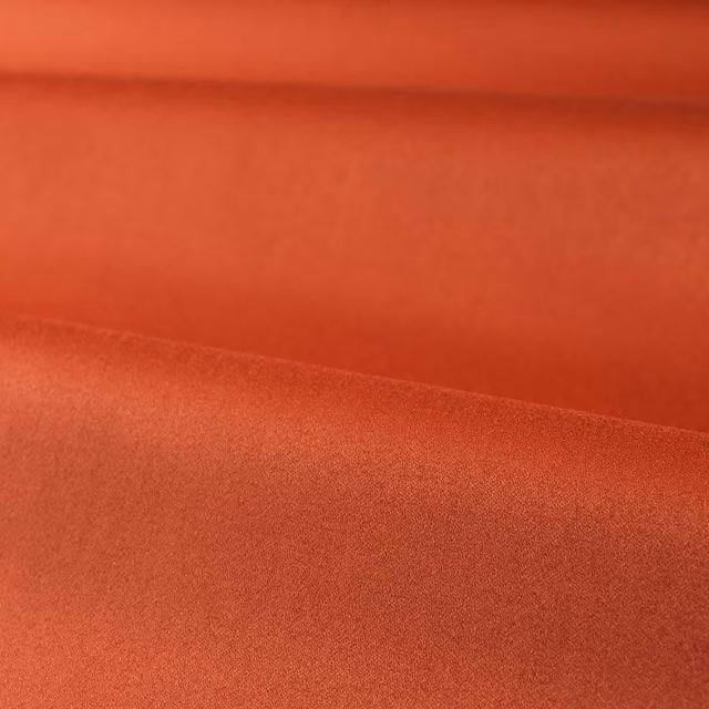 Burnt terracotta red satin with a smooth, softly luminous folded surface