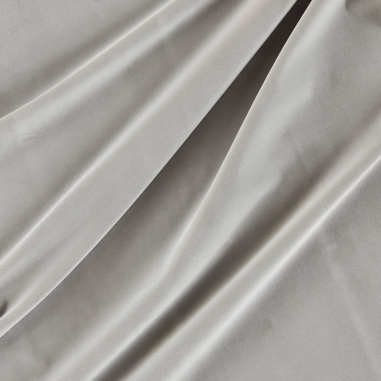 Cool silver-grey velvet with smooth pile and bright highlights along draped folds