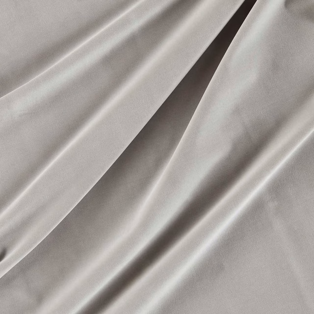 Cool silver-grey velvet with smooth pile and bright highlights along draped folds