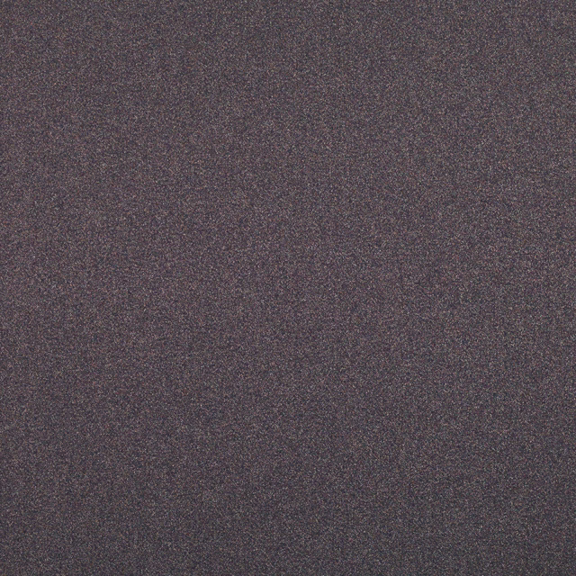 Close-up of dark plum-brown fabric with fine charcoal mottling and a granular surface