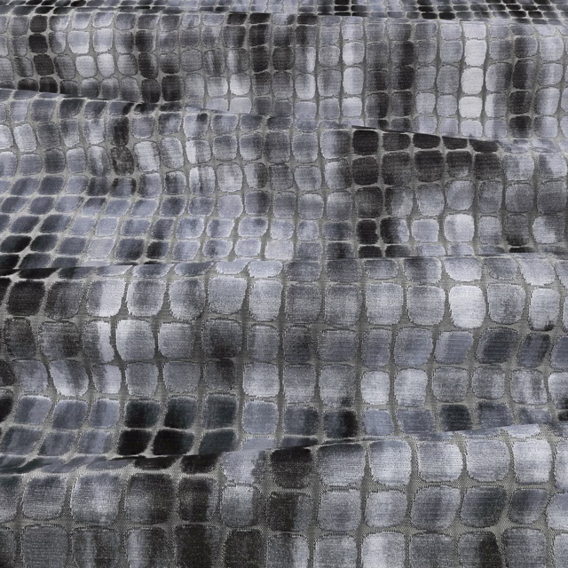 Cool blue-grey textile with irregular charcoal and silver rectangular cells in a softly textured weave