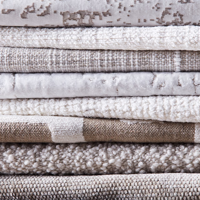 Layered taupe, ivory and stone textiles with abstract driftwood markings and chunky woven textures