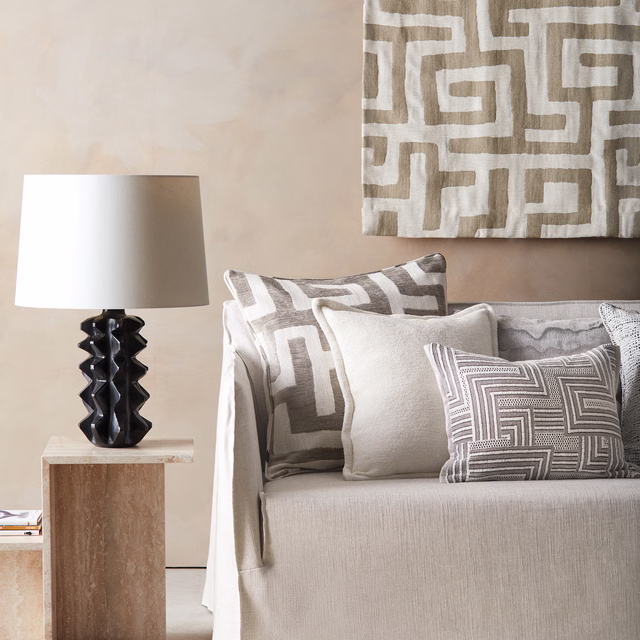 Taupe-and-ivory maze motif textile on chair cushions and a large wall panel