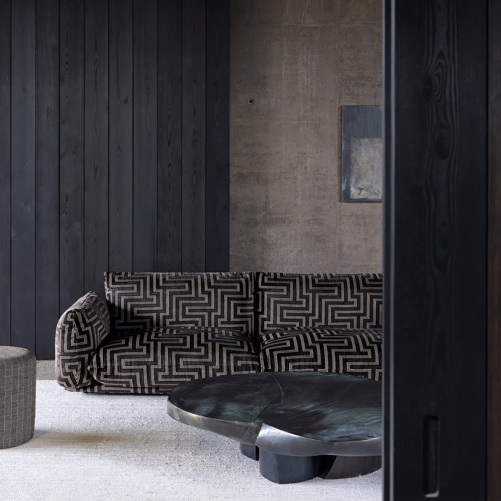 Charcoal sofa upholstered in pale-grey maze-patterned fabric with a dense geometric repeat