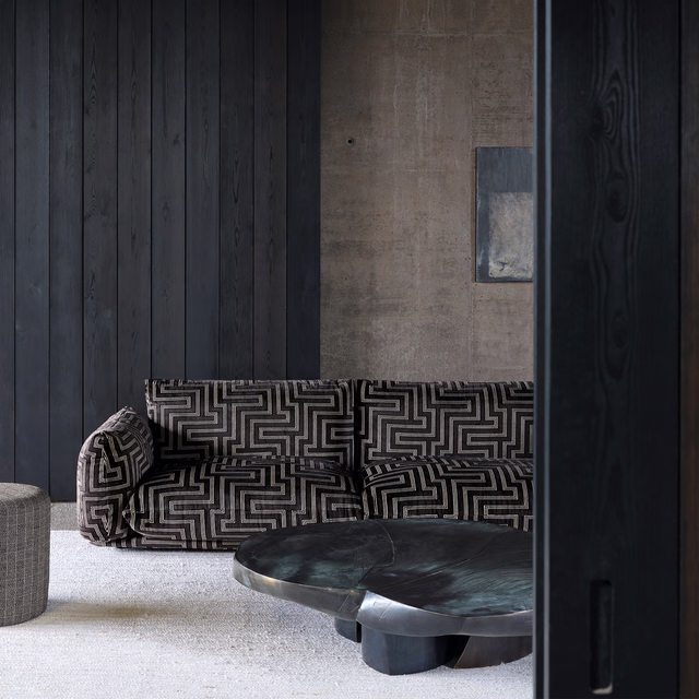 Charcoal sofa upholstered in pale-grey maze-patterned fabric with a dense geometric repeat