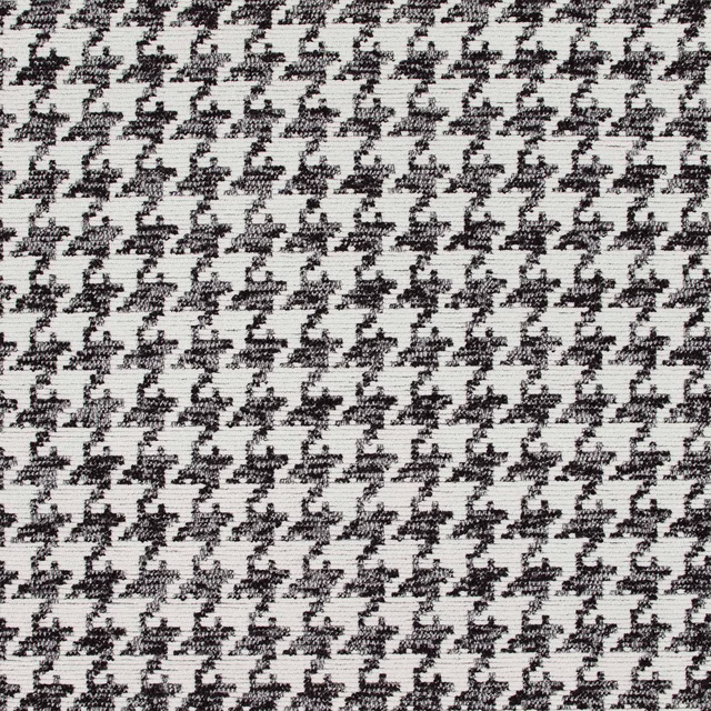 Close-up of ivory woven cloth with repeated black irregular dalmatian-like marks