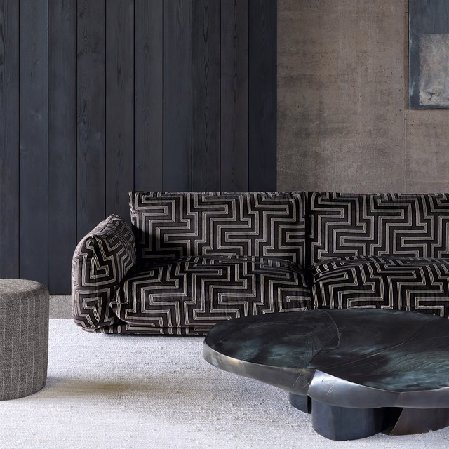 Charcoal and ivory maze-patterned textile upholstered on a curved sofa
