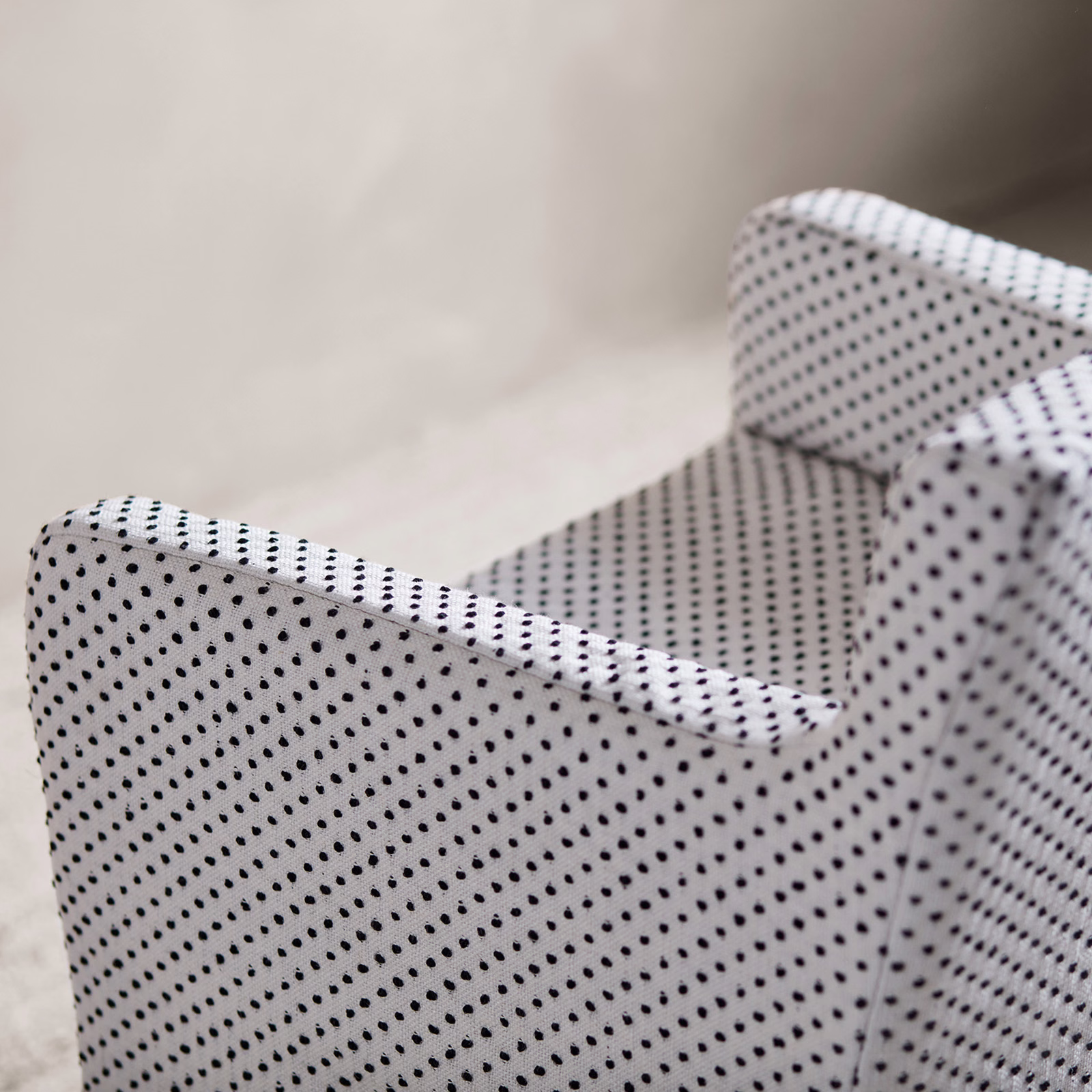 Ivory woven upholstery fabric with diagonal rows of small black dots