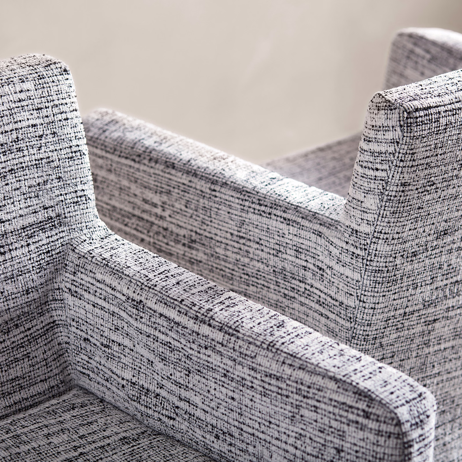 Peppery black-and-white textured weave covering sculpted upholstered armchairs