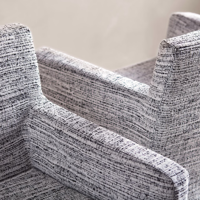 Peppery black-and-white textured weave covering sculpted upholstered armchairs