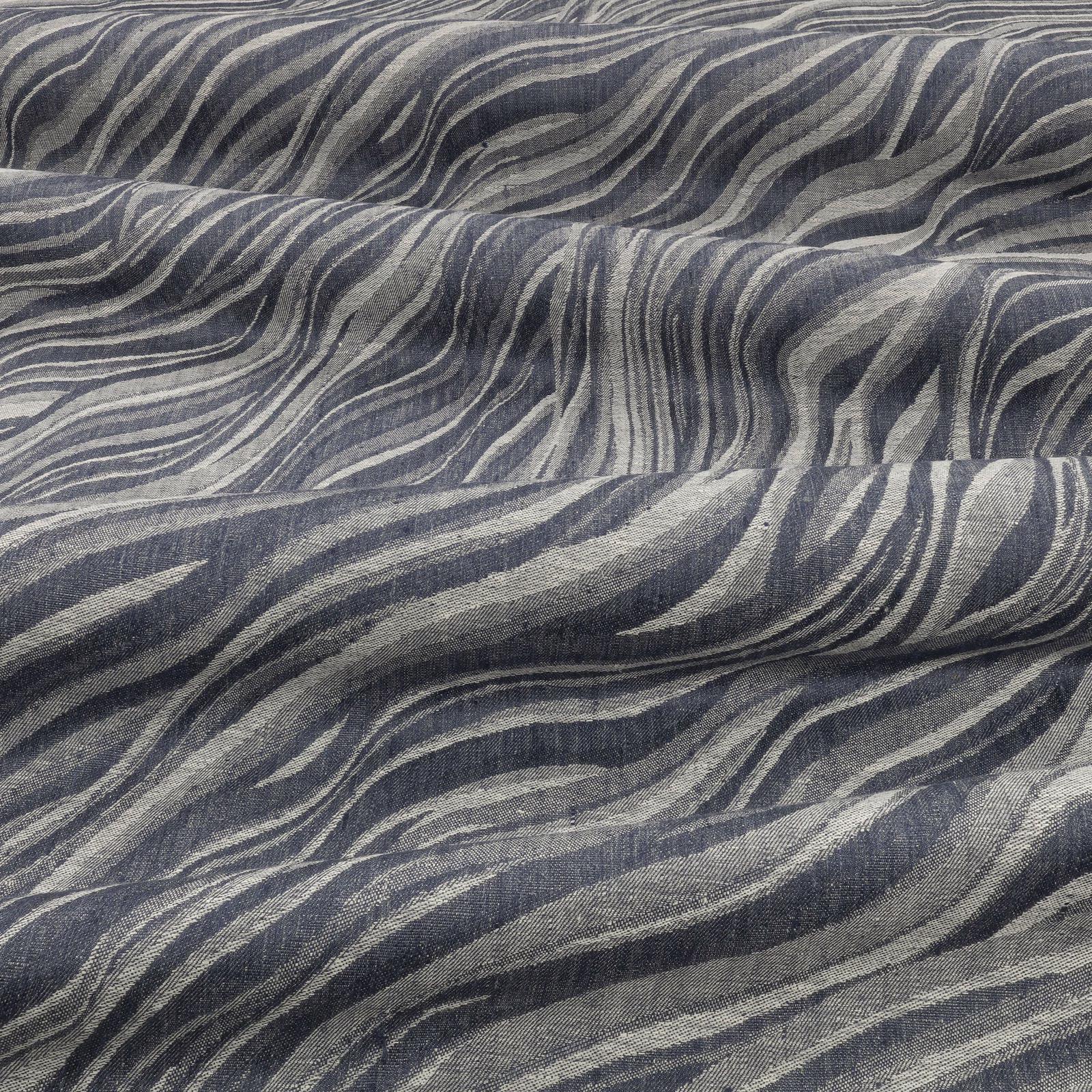 Cool blue-grey textile with charcoal and pale grey flowing wave bands in a woven texture