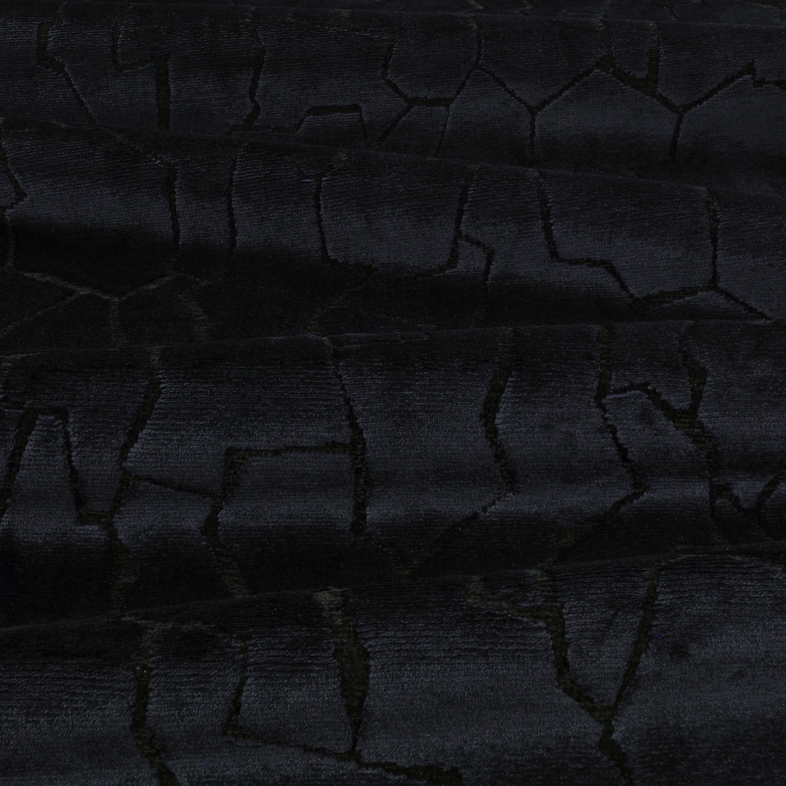 Charcoal-black textile with irregular cracked blocks and a subtly ribbed surface