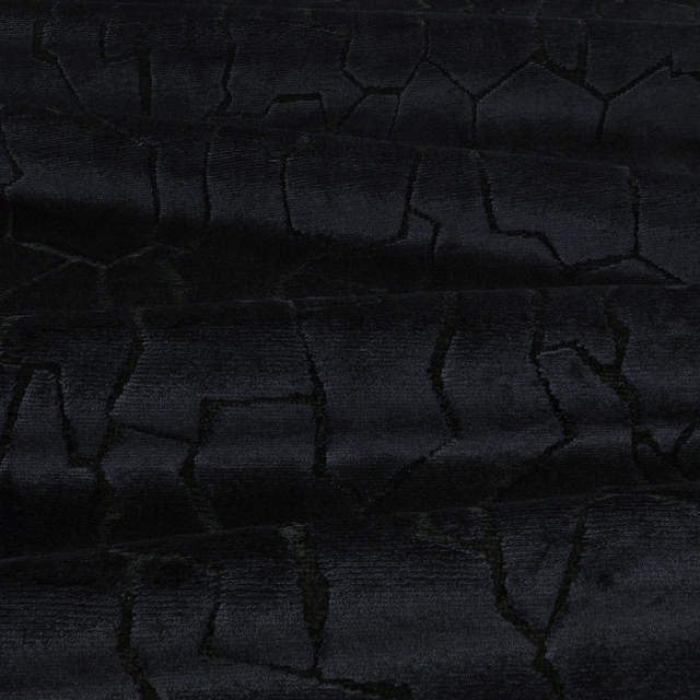 Charcoal-black textile with irregular cracked blocks and a subtly ribbed surface