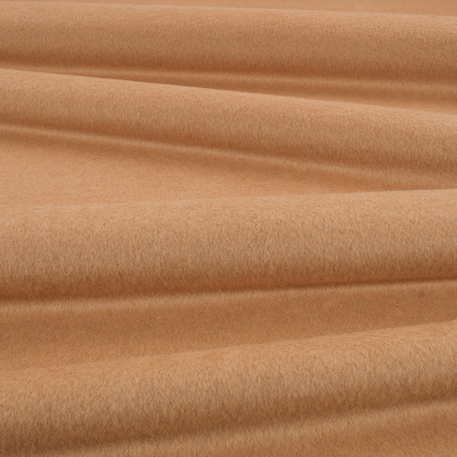 Warm camel fabric with a softly brushed plush surface arranged in flowing folds