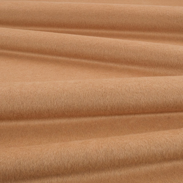 Warm camel fabric with a softly brushed plush surface arranged in flowing folds