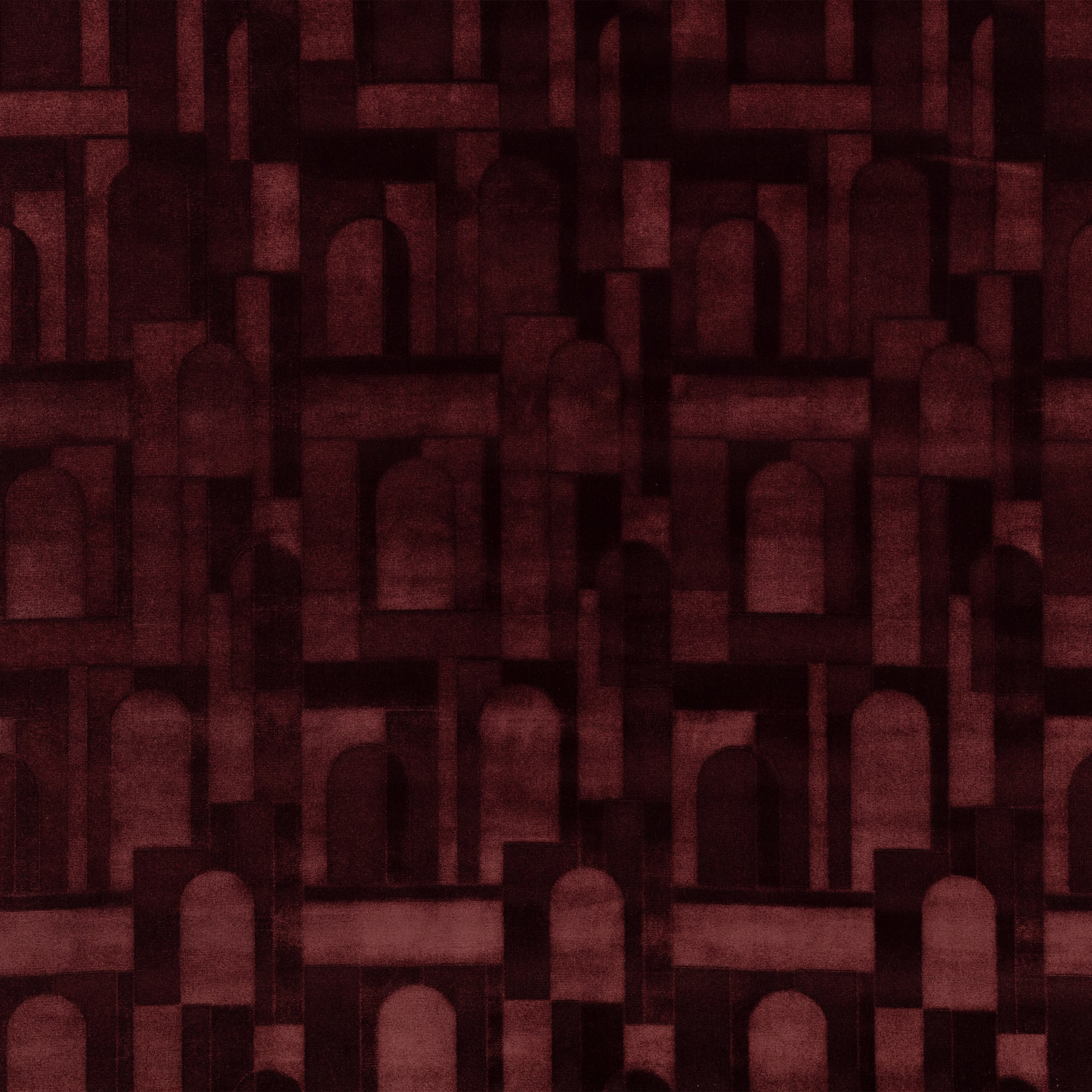 Deep burgundy textile with muted red arches and shadowed geometric blocks