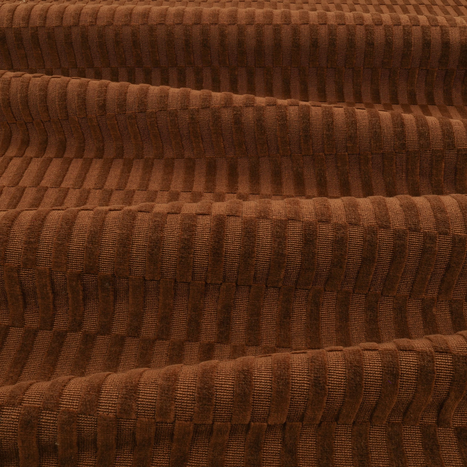 Deep chocolate-brown textile with raised vertical ribs and stepped block-like woven texture