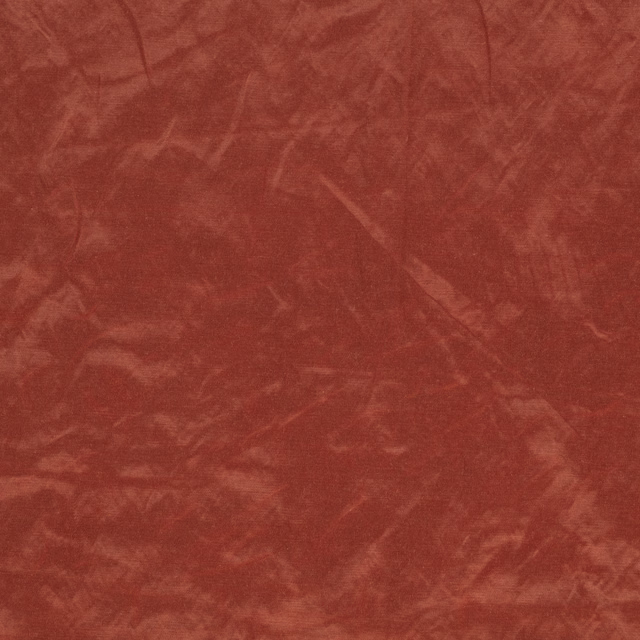 Warm brick-red fabric with mottled, softly brushed tonal texture and subtle linear marks