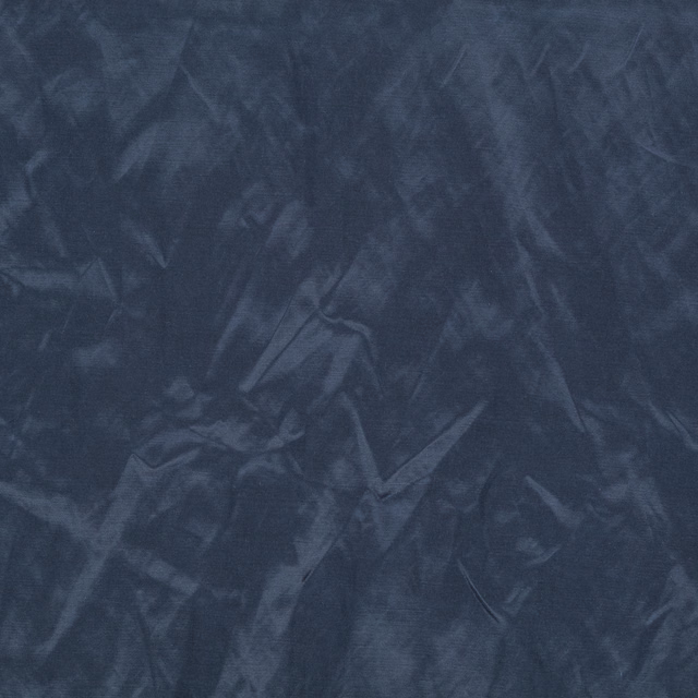 Deep indigo textile with smoky painterly striations and a soft sheen
