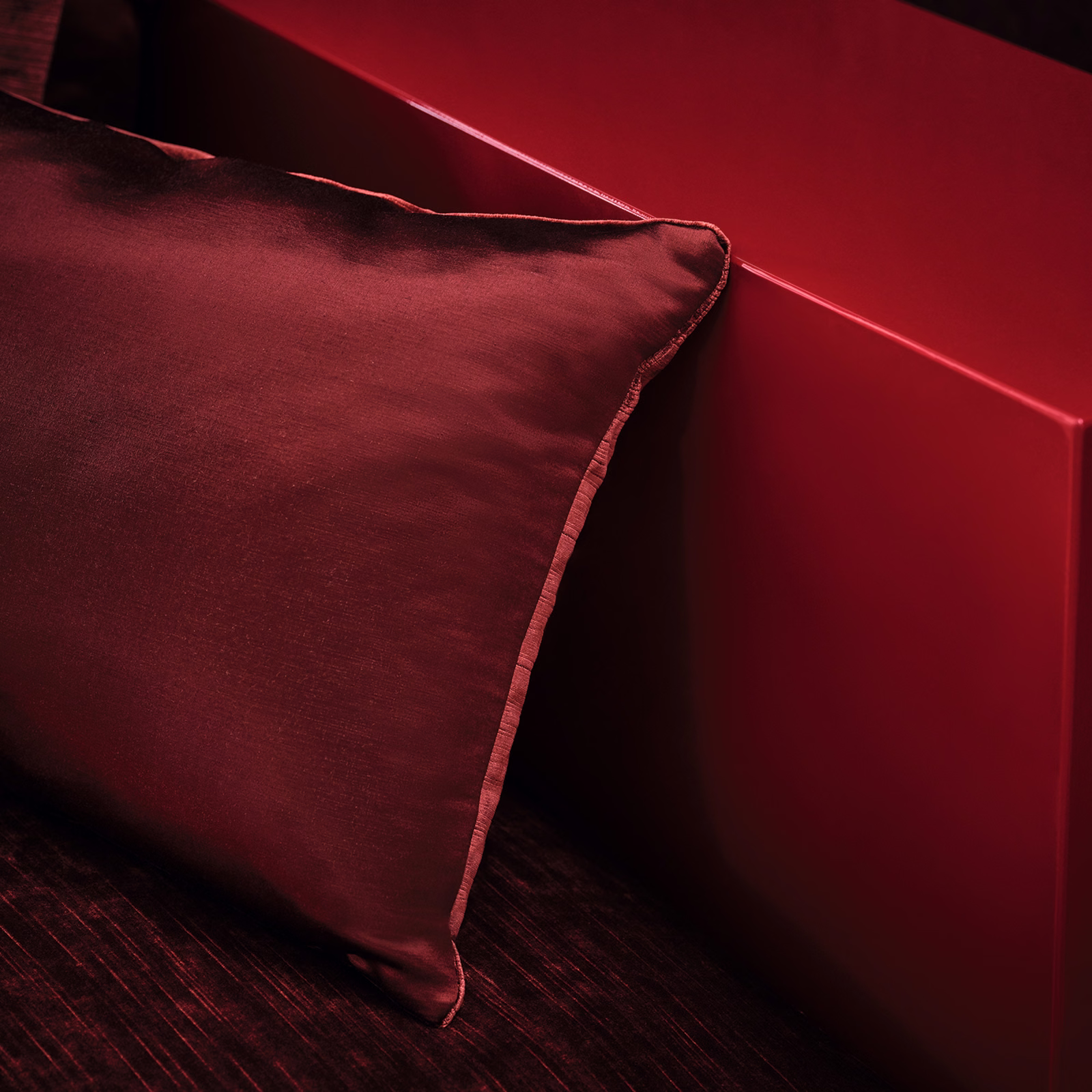 Deep burgundy cushion fabric with soft sheen and a neatly piped edge