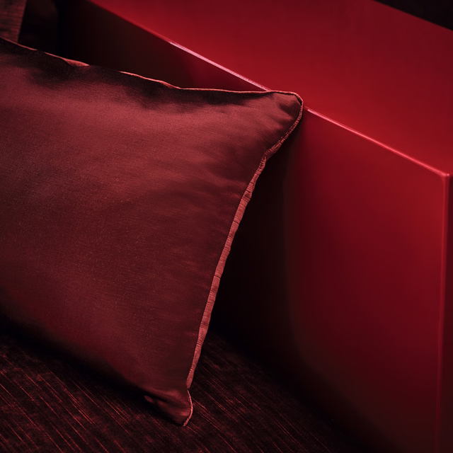 Deep burgundy cushion fabric with soft sheen and a neatly piped edge