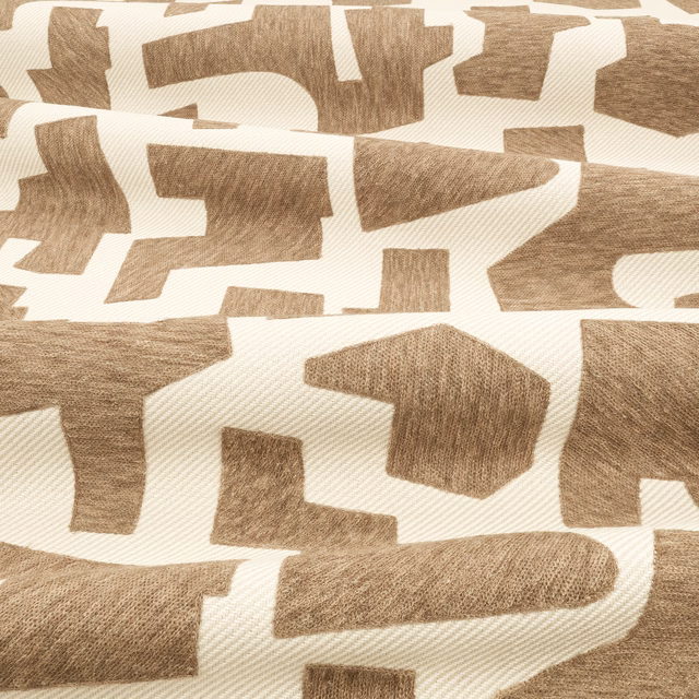 Warm tobacco geometric fragments on a cream, visibly textured woven ground