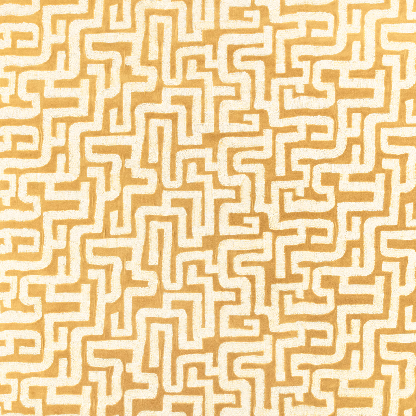 Warm ochre textile with cream maze lines in a dense geometric repeat