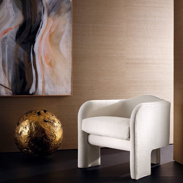 Warm sand-gold textured wallcovering behind a cream chair and dark floor