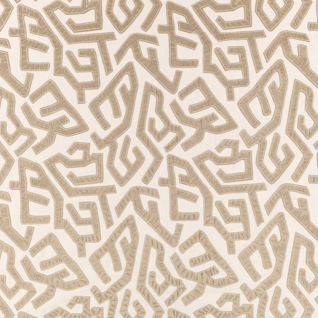 Warm ivory fabric with taupe angular maze motifs and visible woven texture